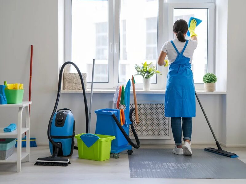 A cleaner working in a bright apartment with professional equipment